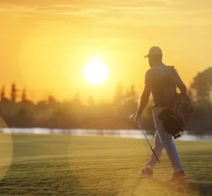 Fit golfer walking at sunset