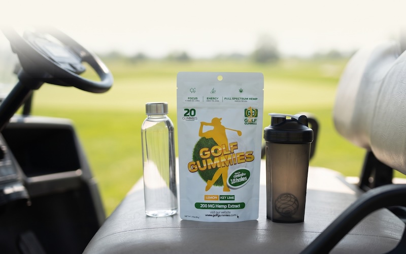 Golfer's supplement lineup on a golf cart — hydration, protein, and Golf Gummies for a full round