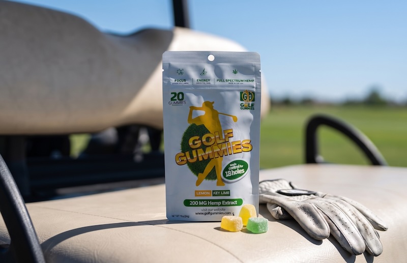 Golf Gummies pouch and loose gummies laid out on a golf course, illustrating what to look for in the best gummies for golfers